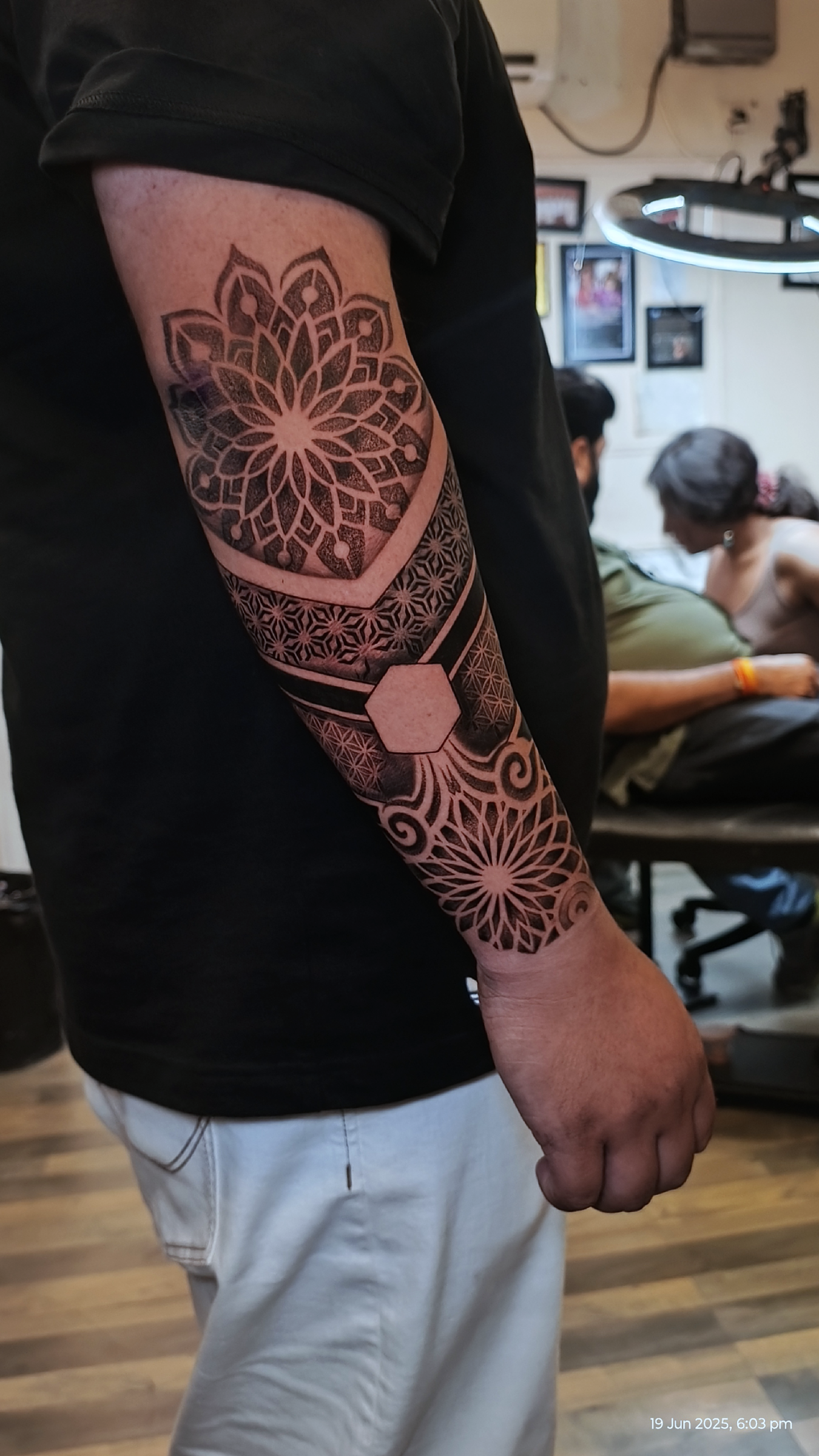 A vibrant, editorial photograph showing a tattoo artist at work in Inkspace Tattoo Studio in Hauz Khas, New Delhi, focusing on tattoo placement.