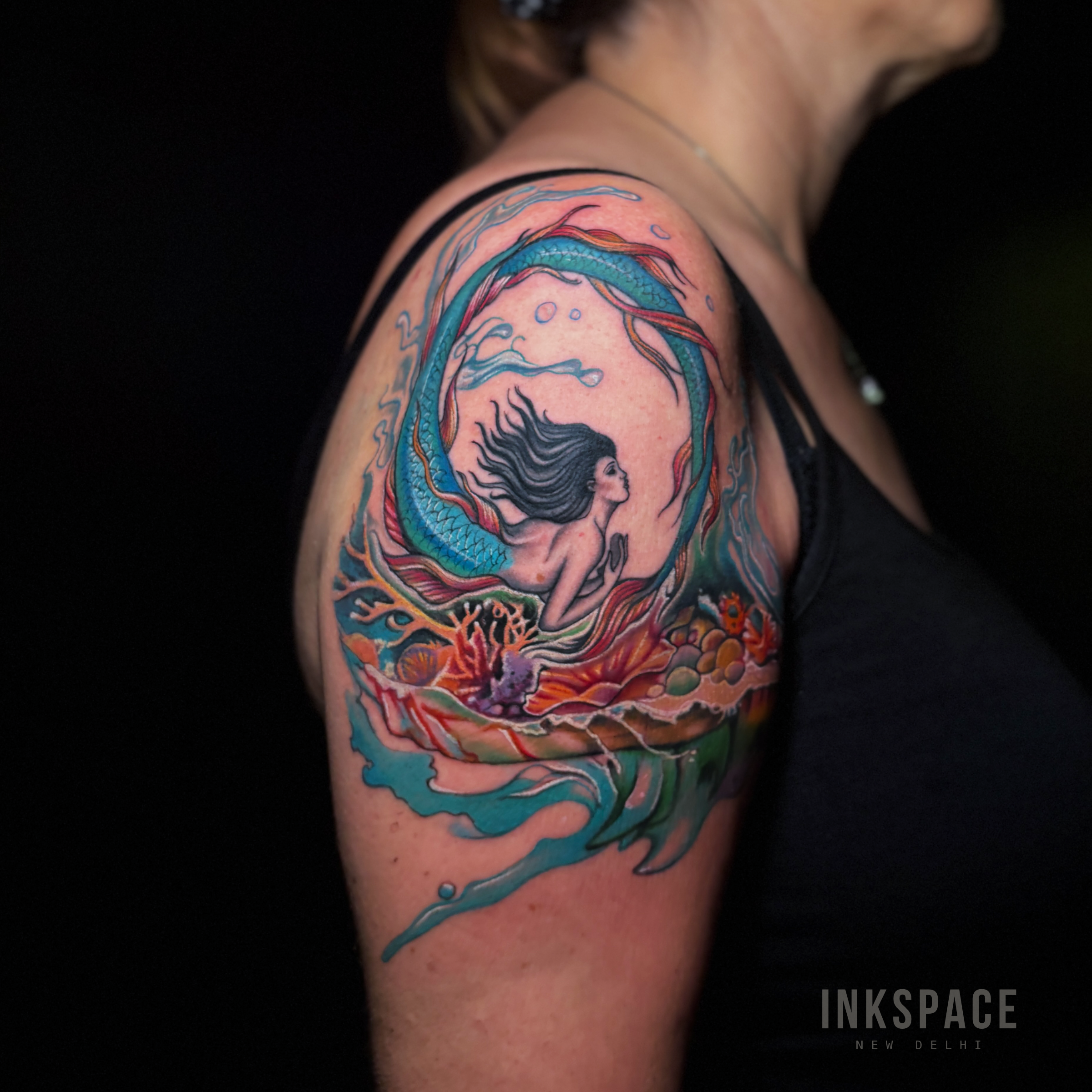 Realism style tattoo fix of an old mermaid design with vibrant new details.