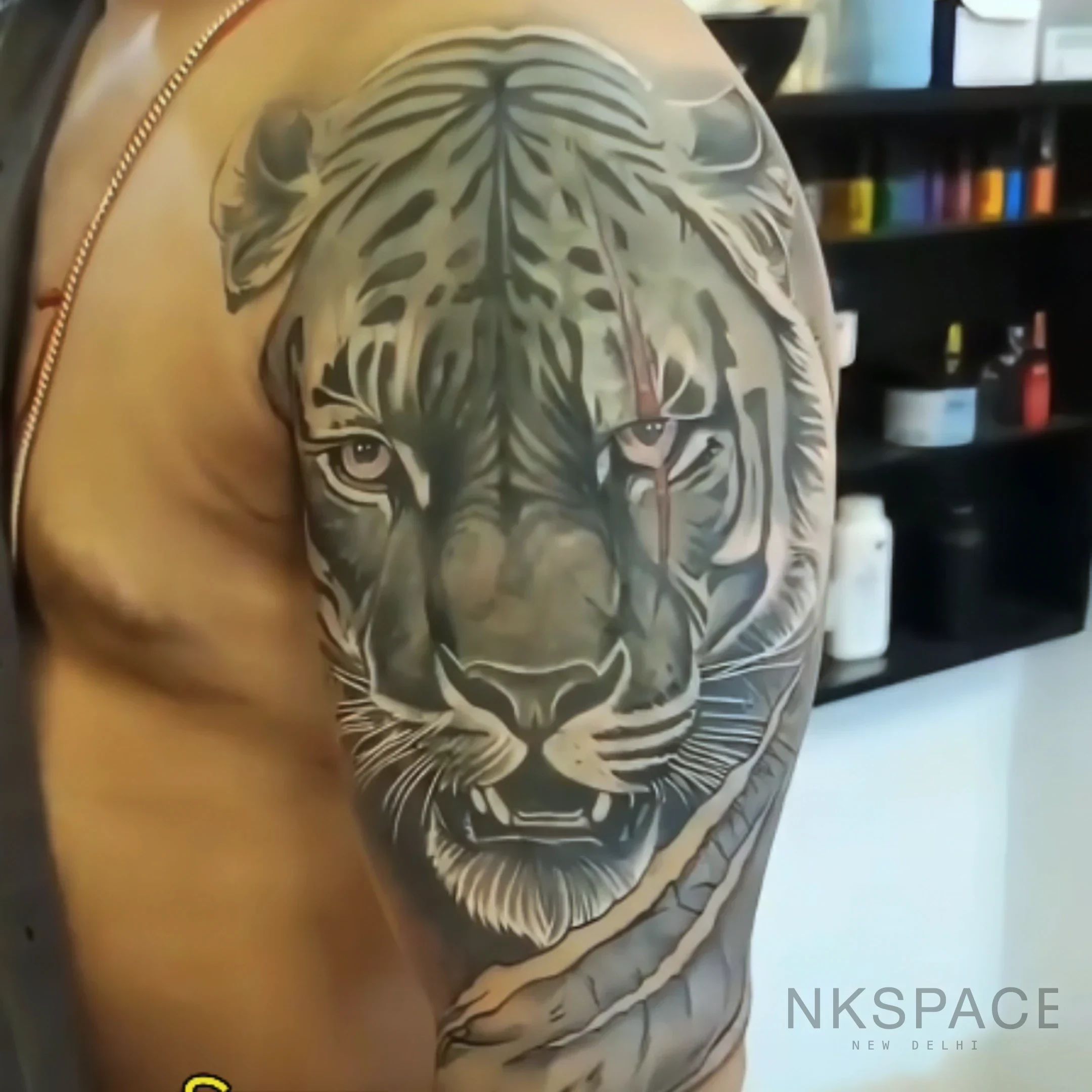 Dynamic cover up roaring tiger tattoo in black and grey, expertly executed by Chetan Salhotra.
