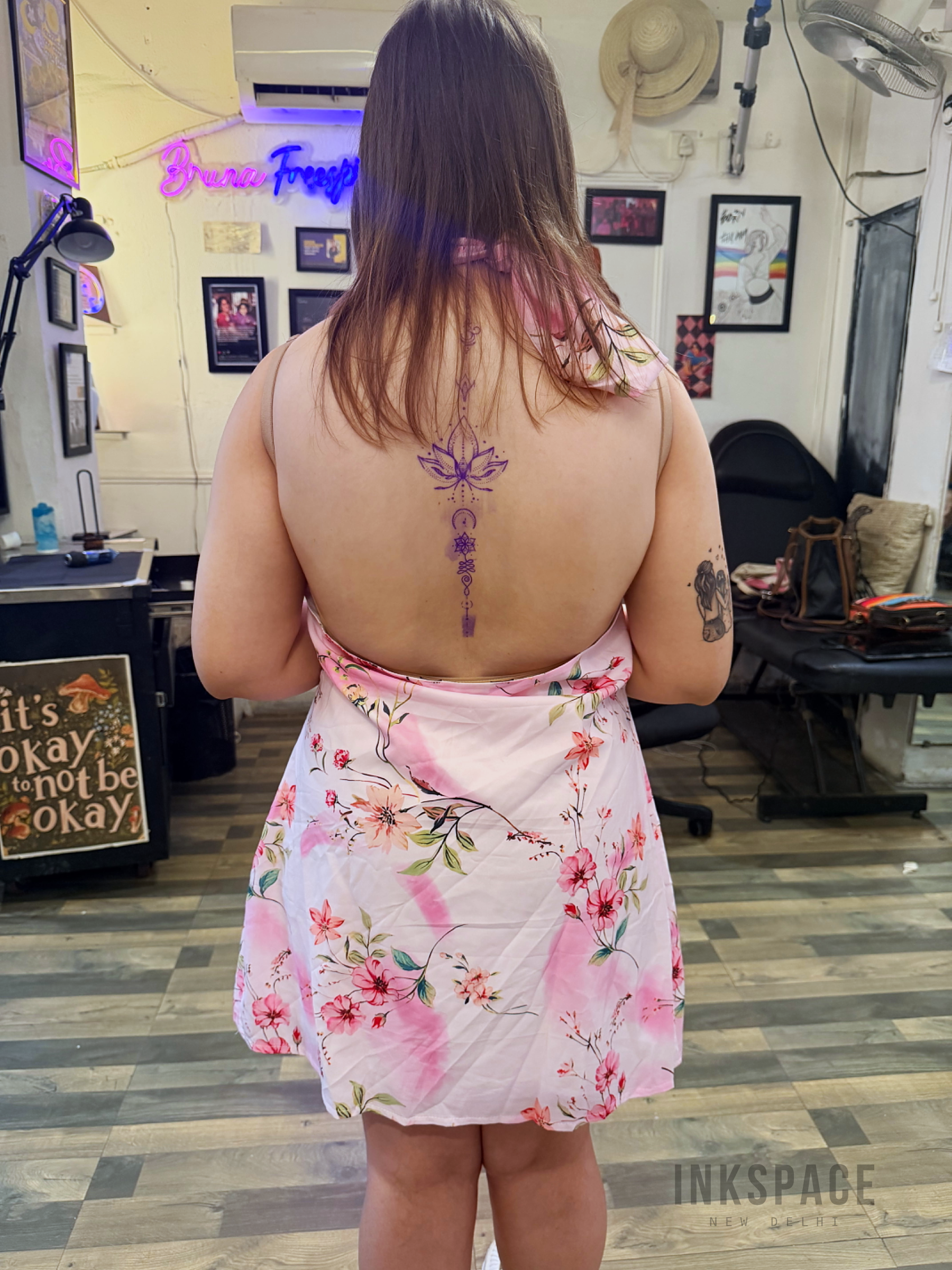 Detailed fine line back tattoo featuring intricate floral designs on a person's back.