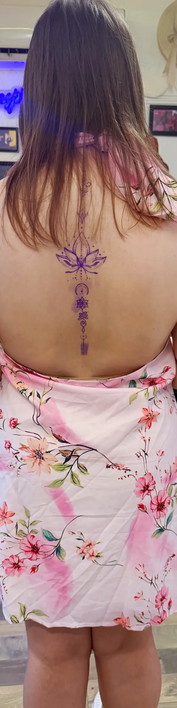 Detailed fine line back tattoo featuring intricate floral designs on a person's back.