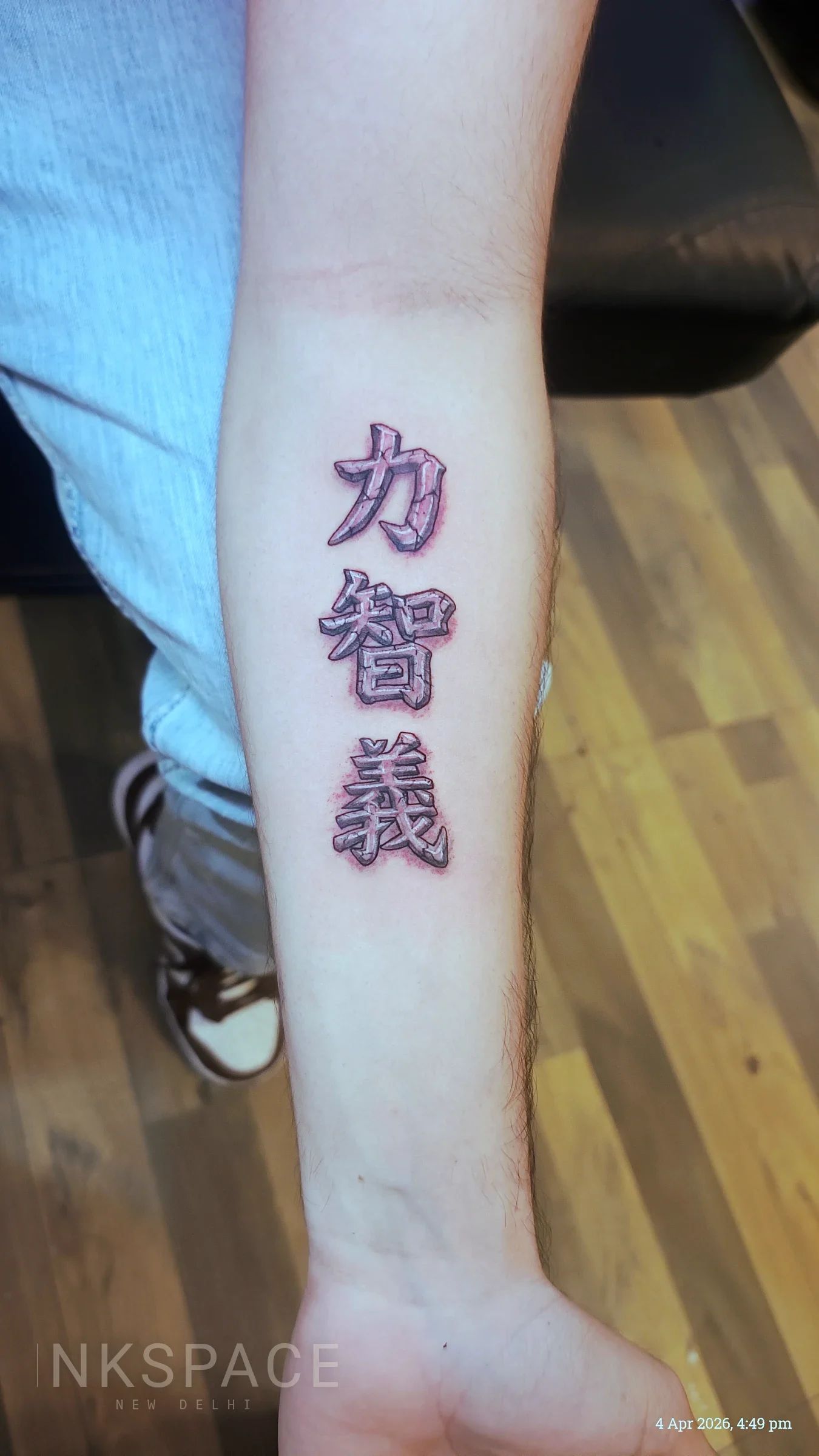 Close-up of a fine line Kanji symbol tattoo on a forearm, featuring delicate lines and precise execution.