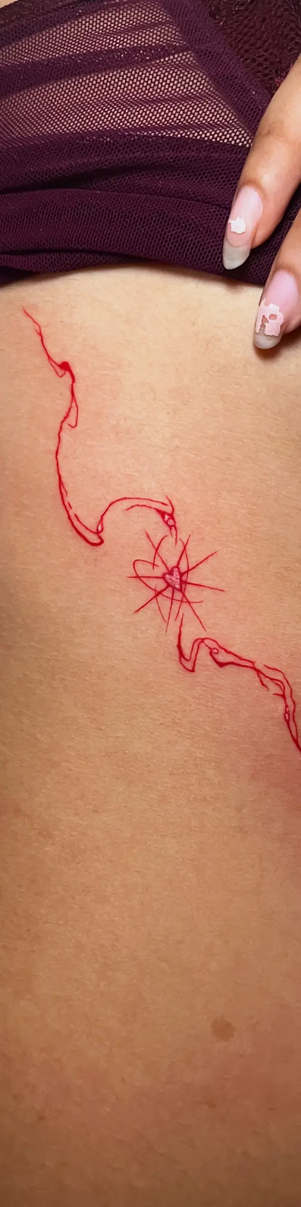 fine line tattoo featuring a single red design