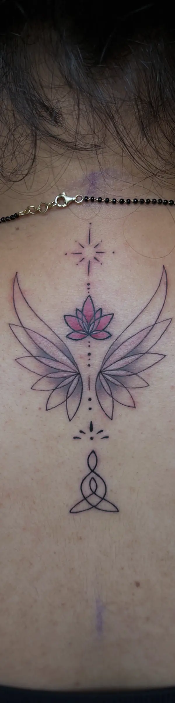 fine line tattoo of lotus flowers and wings